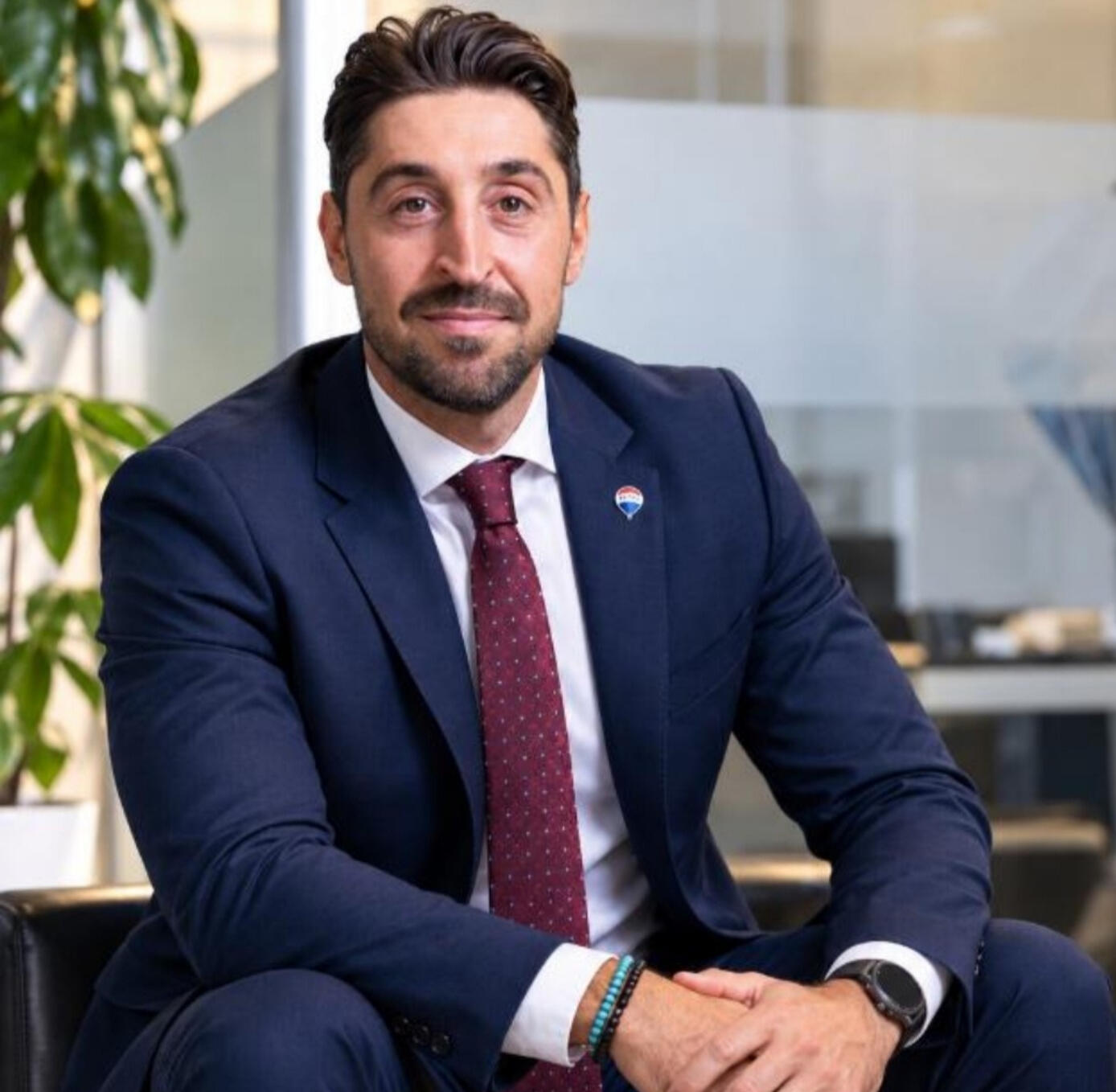 Alessandro Vitale seduto in ufficio, in giacca blu e cravatta.